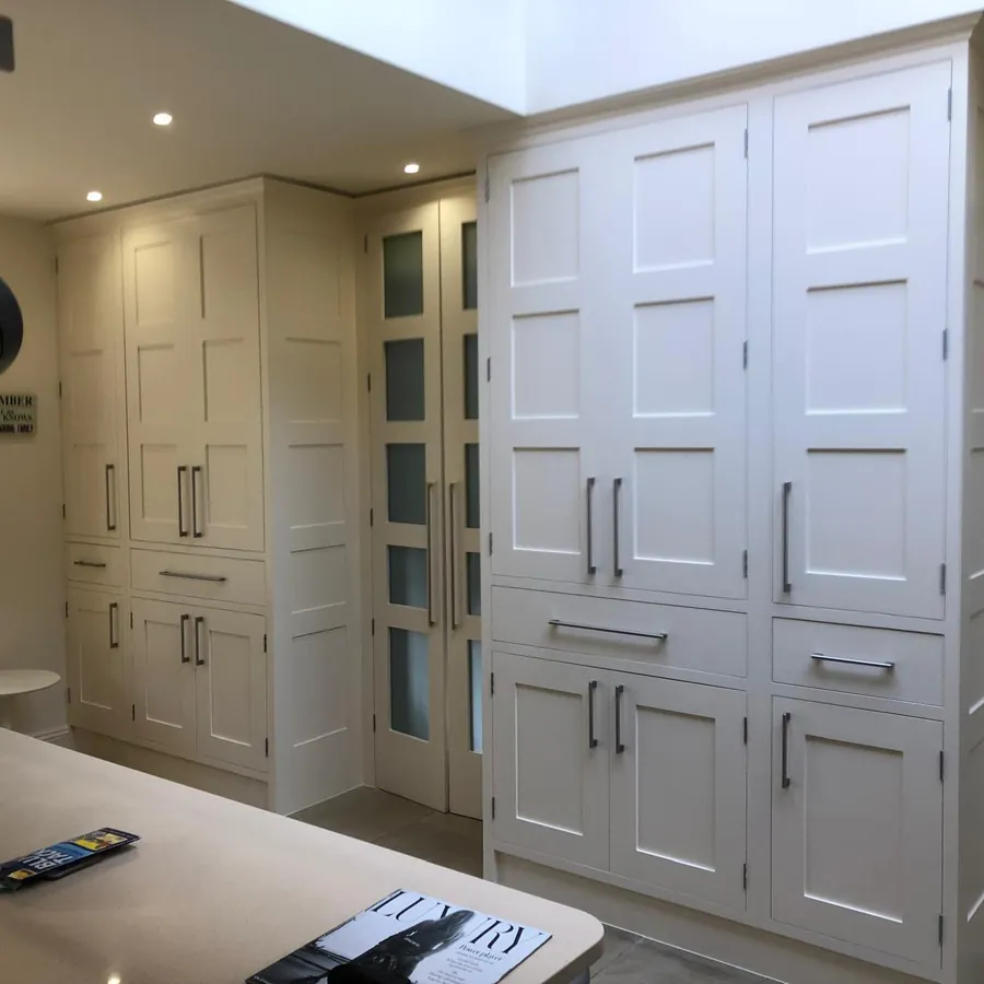 Fitted kitchen cabinetry painted in a soft off-white with shaker doors