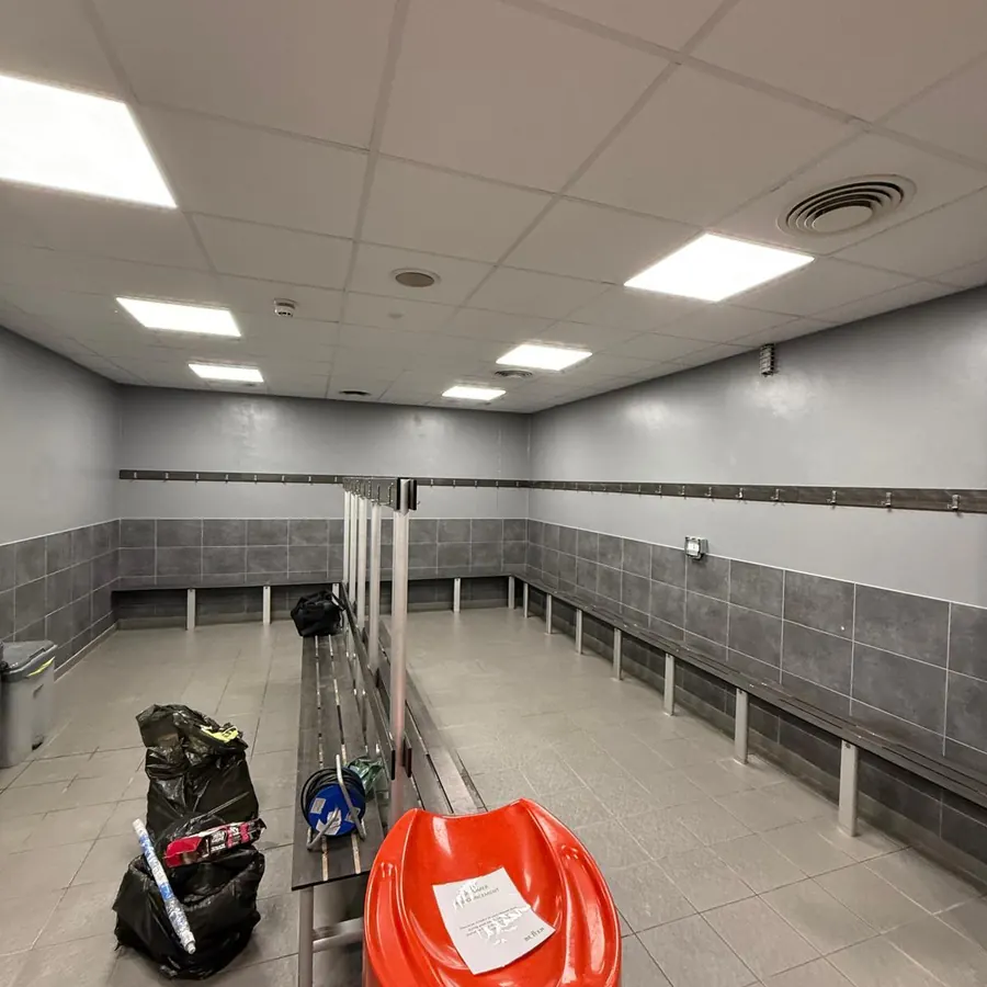 Changing room with painted walls above tiling and bench seating