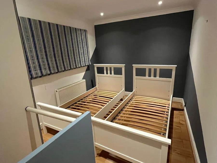 Finished twin room with a charcoal feature wall and white woodwork
